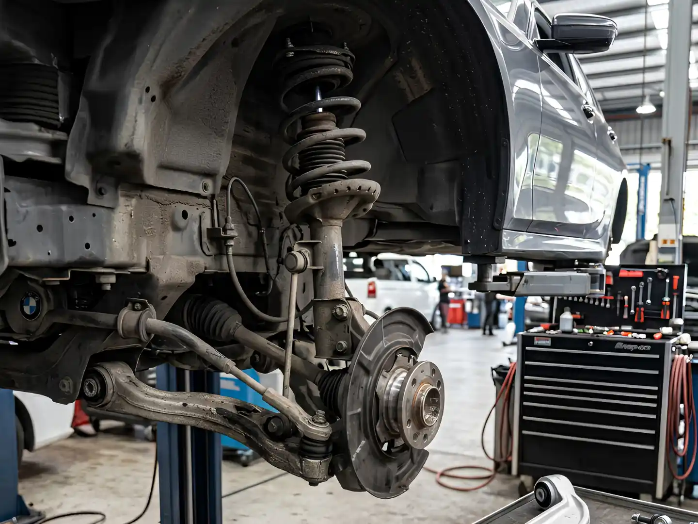 BMW front strut, spring and control arm fitted to the car on a workshop lift
